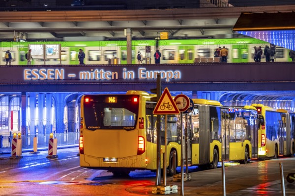 The main train station in Essen, blue illuminated underpass, bus station, am Europaplatz, train on the platform, North Rhine-Westphalia, Germany