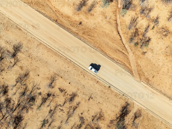 Travel, aerial view, car driving on road through arid landscape, Kunene region, Namibia