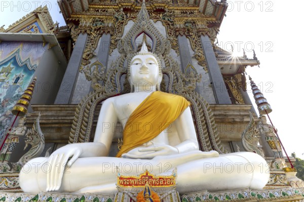 Buddha statue with tunic, Bhumispara mudra, Buddha Gautama at the moment of enlightenment, at the entrance to Wat Sitthawararam, Bangkok, Thailand