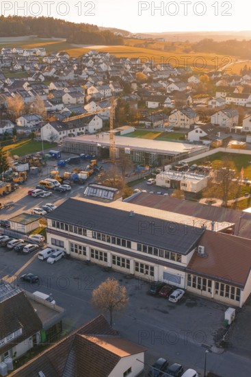 Aerial view of village at sunset with buildings and roads in warm autumn light, Althengstett, Calw district, Germany