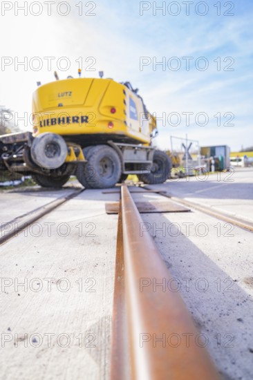 LIEBHERR excavator near rails, blue sky perspective, track preparation, Hermann Hesse Railway track construction, Calw, Germany