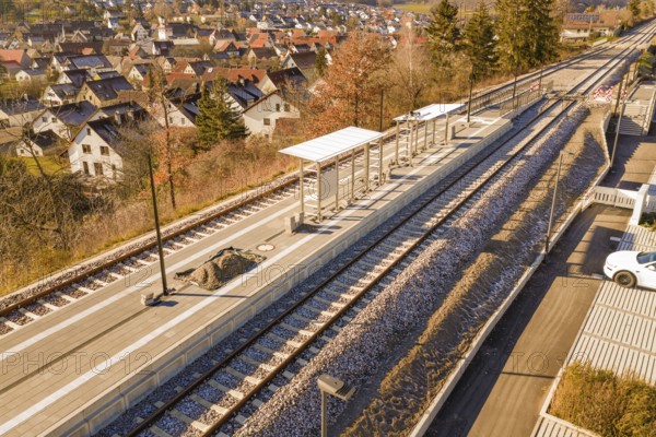 Aerial view of a rural train station with platform roof and tracks in the village, new Hermann Hessebahn station, Ostelsheim, Calw district, Germany