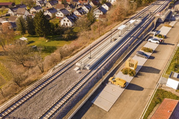 Station in the village with adjacent parking spaces and surrounding autumn landscape, new Hermann Hessebahn station, Ostelsheim, Calw district, Germany