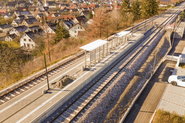 Station with two tracks in a small village surrounded by autumn trees, new Hermann Hessebahn station, Ostelsheim, Calw district, Germany