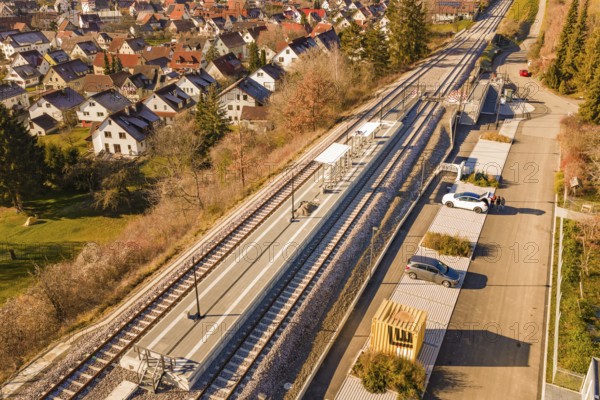 Aerial view of a village with a small train station surrounded by houses and autumn vegetation, new Hermann Hessebahn railway station, Ostelsheim, Calw district, Germany