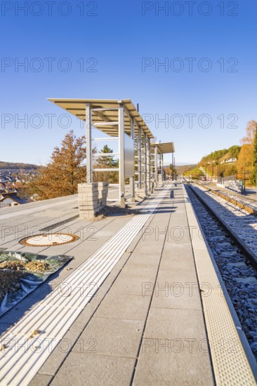 Autumn platform with modern architectural elements under clear skies, new Hermann Hessebahn railway station, Ostelsheim, Calw district, Germany