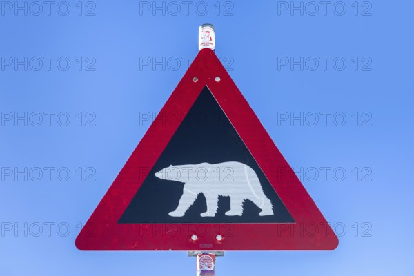 Polar bear warning sign against blue sky, Spitsbergen, Svalbard, Norway