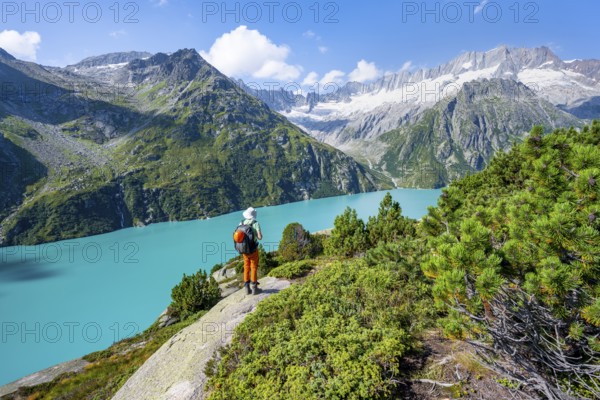 Mountaineers in front of picturesque mountain landscape, turquoise-blue mountain lake Göscheneralpsee, Dammastock and Damma Glacier, Göscheneralp, Canton of Uri, Switzerland