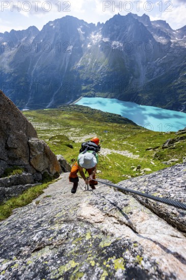 Mountaineer climbs on the secured Schijen-Zwärg via ferrata, climb to Bergseehütte, Göscheneralp in the back, Canton of Uri, Switzerland