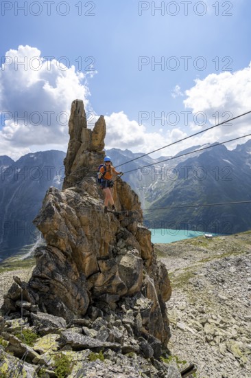 Crocodile rock formation, mountaineer on rope bridge in the Crocodile Mountain Lake via ferrata on Bergseeschijen-Vorbau, Göscheneralp, Canton of Uri, Switzerland