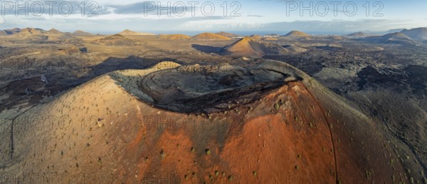 Caldera Colorada volcano, picturesque volcanic landscape with volcanic craters and lava fields in morning light, Parque Natural de Los Volcanes, aerial view, Lanzarote, Canary Islands, Spain