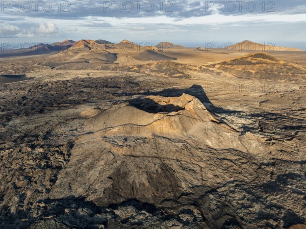 Volcán de Las Nueces volcano, picturesque volcanic landscape with volcanic craters and lava fields in morning light, Parque Natural de Los Volcanes, aerial view, Lanzarote, Canary Islands, Spain
