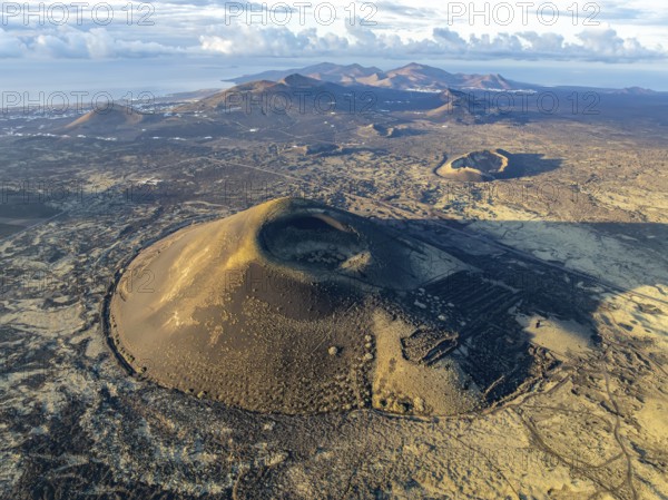 Montaña Negra volcano, picturesque volcanic landscape with volcanic craters and lava fields in morning light, Parque Natural de Los Volcanes, aerial view, Lanzarote, Canary Islands, Spain