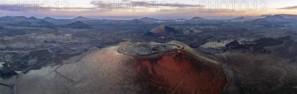 Caldera Colorada volcano, picturesque volcanic landscape with volcanic craters at sunrise, Los Volcanes Natural Park, aerial view, Lanzarote, Canary Islands, Spain
