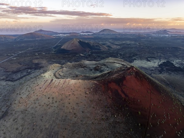 Caldera Colorada volcano, picturesque volcanic landscape with volcanic crater at sunrise, Parque Natural de Los Volcanes, aerial view, Lanzarote, Canary Islands, Spain