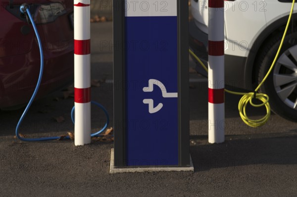 Parking lot with gas pump, EnBW charging station for electric cars, charging station, e-charging station, e-mobility, charging cable leads into two vehicles, e-car, pictogram, logo, Stuttgart, Baden-Württemberg, Germany