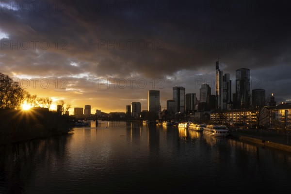 The sun sets behind the Main and bathes Frankfurt's banking skyline in orange-yellow light, Alte Brücke, Frankfurt am Main, Hesse, Germany