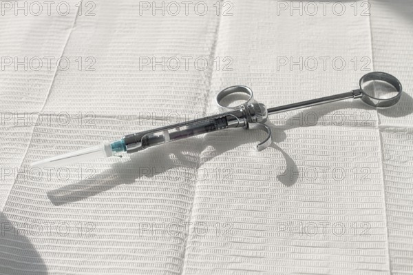 A carpal syringe, reusable, for use in dentistry, for the administration of anesthetic, lies on the table