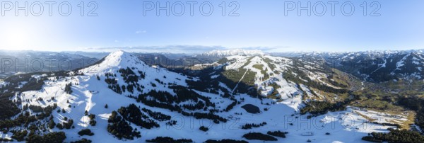 Wonderful winter landscape with Hohe Salve, blue sky and snow, mountains and mountain valley, aerial view of Skiwelt Wilder Kaiser ski area, Brixental, Tyrol, Austria