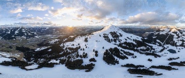 Sunset, alpine panorama, fantastic winter landscape with Hohe Salve, blue sky and snow, mountains and mountain valley, aerial view Skiwelt Wilder Kaiser ski area, Brixental, Tyrol, Austria