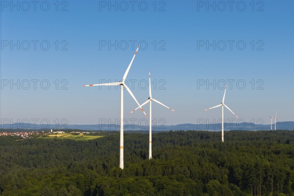 Wind power plants in a wooded area under a bright blue sky, near Schorndorf, Remstal, Baden-Württemberg, Germany