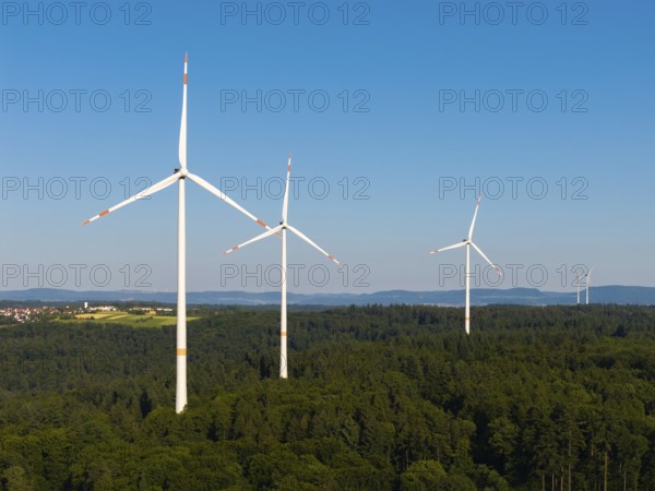 Several wind turbines stretch into the sky over an extensive forest area, near Schorndorf, Remstal, Baden-Württemberg, Germany