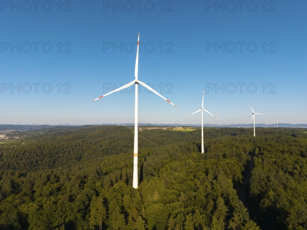 Wind turbines over dense forest stretch into the vastness of the sky, near Schorndorf, Remstal, Baden-Württemberg, Germany