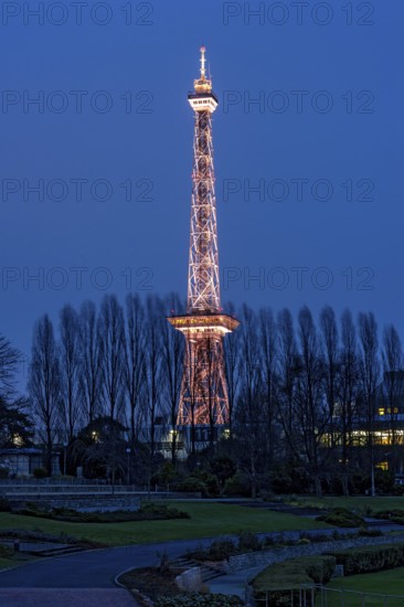Red illuminated Berlin radio tower, half-timbered steel building by architect Heinrich Straumer, Langer Lulatsch, old radio tower, television tower, heritage-protected building, summer garden, exhibition center, Messe Berlin, dusk, blue hour, Berlin, Germany