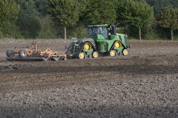 Crawler tractors harrow the field, Othenstorf, Mecklenburg-Western Pomerania, Germany