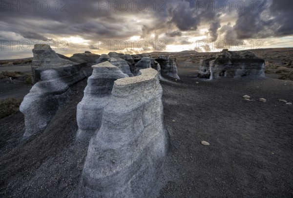 Eroded rock formations, volcanic landscape with dramatic cloudy sky at sunset, Ciudad Estratificada or Los Roferos, Antigua Rofera de Teseguite, Lanzarote, Canary Islands, Spain