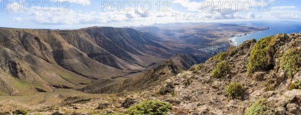 Panorama at Castillejo viewpoint, view from the Risco de Famara cliffs to the coast and the sea with Famara beach, Playa de Famara with La Calaeta, Lanzarote, Canary Islands, Spain