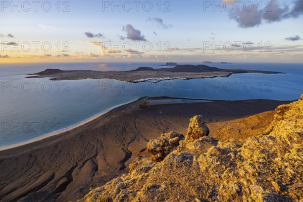 View of steep cliffs to sea and the island of La Graciosa, Mirador del Porrito viewpoint at sunset, Lanzarote, Canary Islands, Spain
