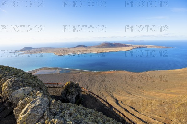 View of La Graciosa island with volcanic craters in the evening light, Mirador del Río viewpoint designed by artist César Manrique, Lanzarote, Canary Islands, Spain