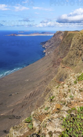 Castillejo viewpoint, view from the Risco de Famara cliffs to the coast and the sea with the Famara beach, Playa de Famara, Lanzarote, Canary Islands, Spain