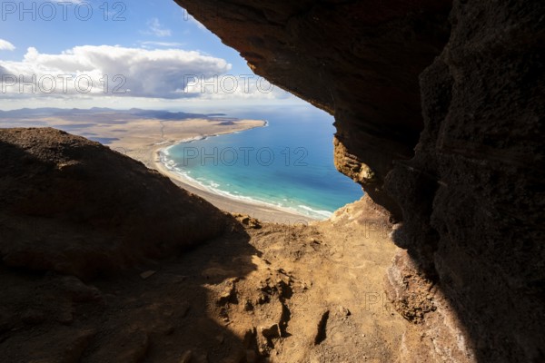 Cueva de las Cabras cave, view from the Risco de Famara cliffs on Famara beach, Playa de Famara with La Calaeta, Lanzarote, Canary Islands, Spain