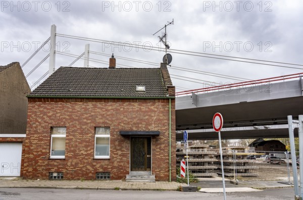 Residential buildings, directly on the A40 Neuenkamp bridge, in Duisburg-Homberg, pillars and cables of the new motorway bridge across the Rhine near Duisburg, construction phase of the 2nd bridge structure, North Rhine-Westphalia, Germany
