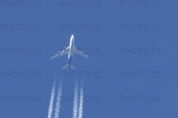 Boeing 747 jumbo jet cargo aircraft of Atlas air airlines flying in a blue sky with contrails or vapour trails behind, England, United Kingdom