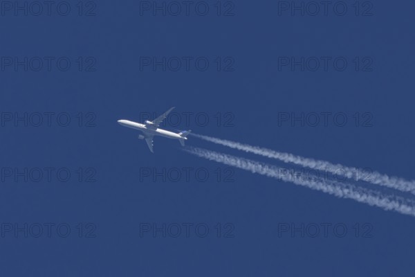 Boeing jet passenger aircraft of United airways airlines flying in a blue sky with contrails or vapour trails behind, England, United Kingdom