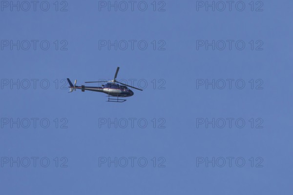 Airbus H125 helicopter flying in a blue sky, England, United Kingdom