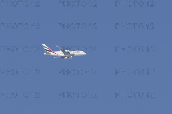 Airbus A380 jet passenger aircraft of Emirates airlines flying in a blue sky, England, United Kingdom