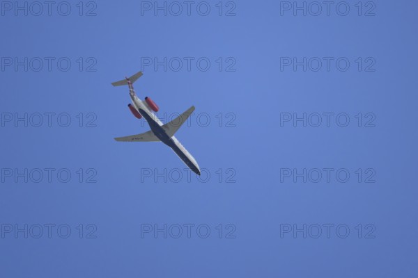 Embraer ERJ-145 jet passenger aircraft of Loganair airlines flying in a blue sky, England, United Kingdom