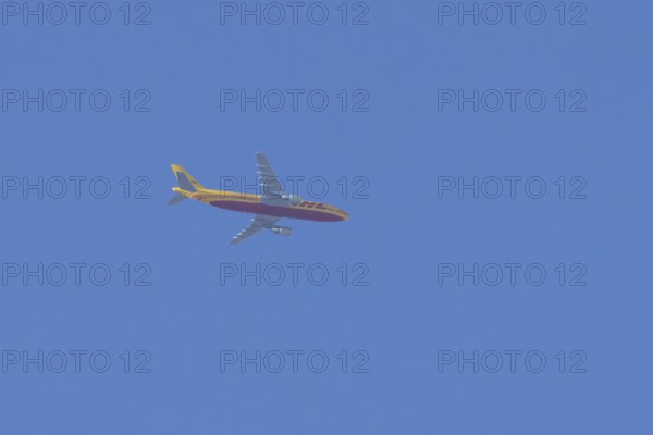 Boeing 767 jet cargo aircraft of DHL airlines flying in a blue sky, England, United Kingdom