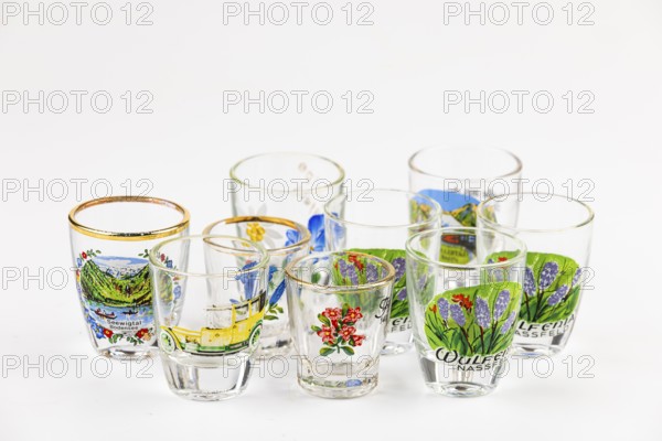 Collection of several decorated shot glasses, some with landscape and floral motifs