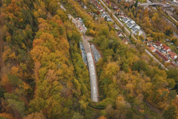 City panorama with view of a train tunnel in an autumnal forest, Hermann-Hesse-Bahn construction site, Calw, Germany