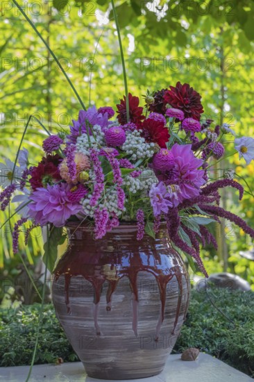 A colorful bouquet of flowers in a decorative vase in the garden, North Rhine-Westphalia, Germany