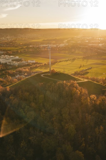 A hilly autumn landscape with wind turbine in warm sunset, Grüner Heiner, Korntal, Germany