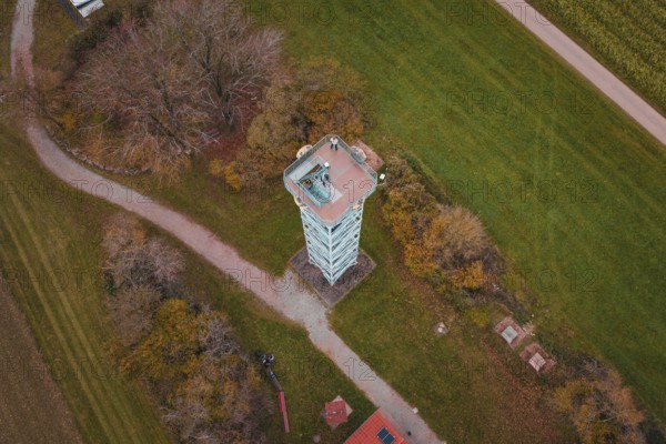 An observation tower in the middle of a rural landscape with fields and buildings, surrounded by autumn colors, Dürrenmettstetten observation tower, Germany
