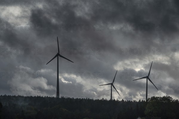 Wind turbines in pine forest during thunderstorm, Bavarian Forest, Bavaria, Germany