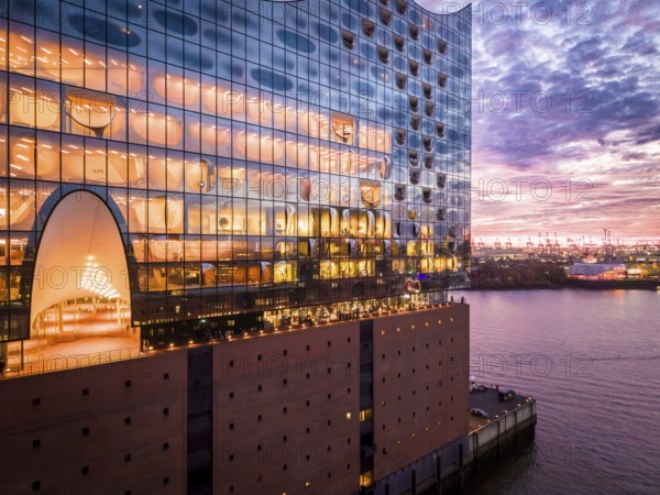 Aerial view of the Elbe Philharmonic Hall with reflections on the façade in the evening light above the harbor, Hamburg, Germany