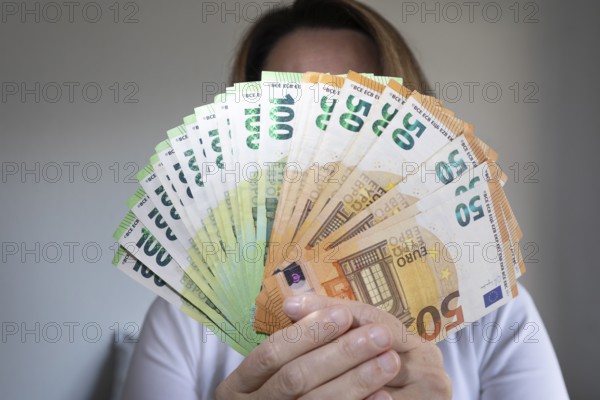 Human hand with several 50 and 100 euro banknotes
